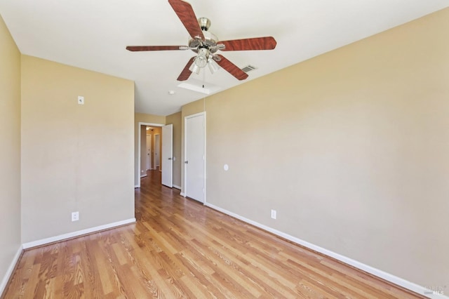 unfurnished room featuring a ceiling fan, baseboards, light wood finished floors, and visible vents