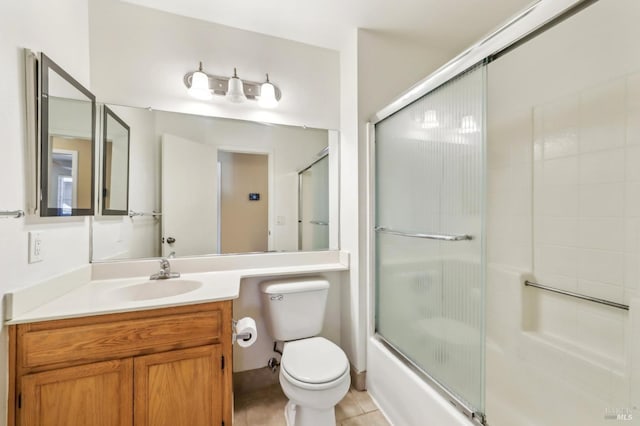 bathroom featuring toilet, vanity, shower / bath combination with glass door, and tile patterned flooring