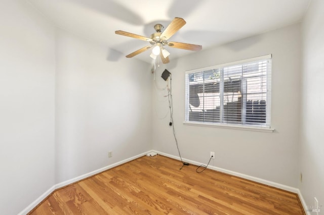 spare room with baseboards, ceiling fan, and light wood-style floors