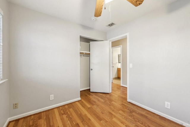 unfurnished bedroom featuring baseboards, a closet, visible vents, and light wood-style floors