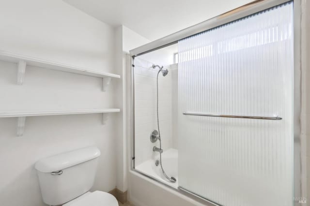 full bath with toilet and shower / bath combination with glass door