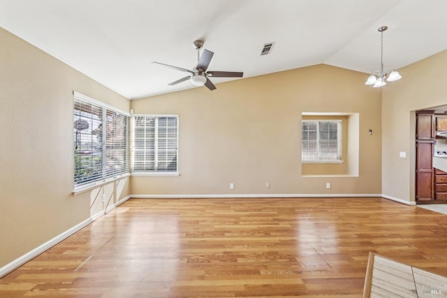 unfurnished living room featuring visible vents, baseboards, lofted ceiling, light wood-type flooring, and ceiling fan with notable chandelier