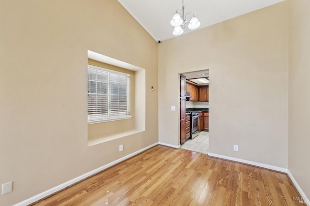 unfurnished dining area featuring light wood finished floors, baseboards, high vaulted ceiling, and a chandelier