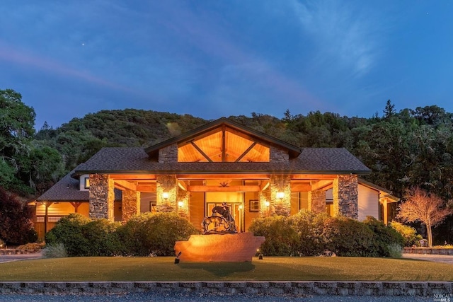 view of front of property with stone siding and a front lawn