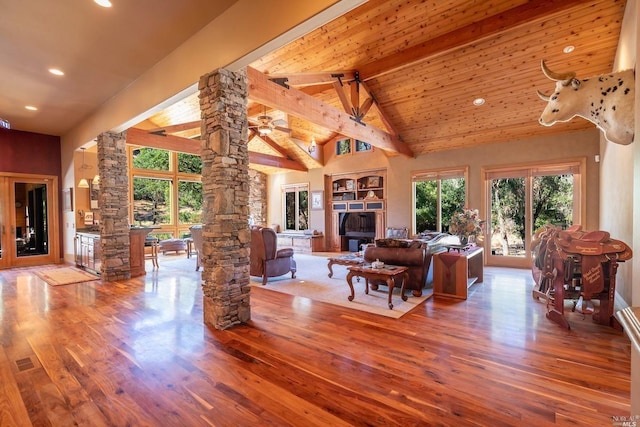 living area featuring recessed lighting, decorative columns, high vaulted ceiling, beam ceiling, and wood finished floors