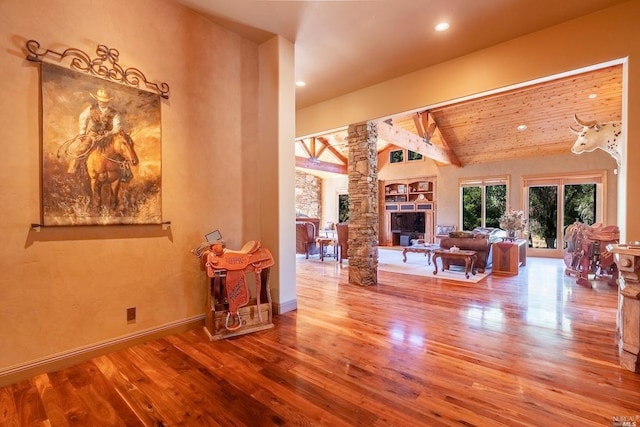 living room with vaulted ceiling with beams, decorative columns, wood finished floors, and baseboards