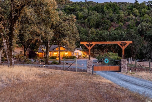 view of property's community with a gate and a forest view