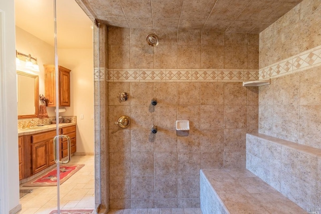 bathroom with a tile shower and vanity