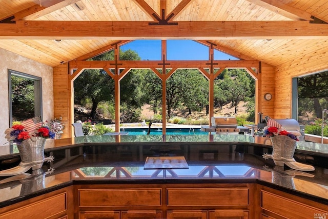 kitchen with wood ceiling, vaulted ceiling with beams, and brown cabinets