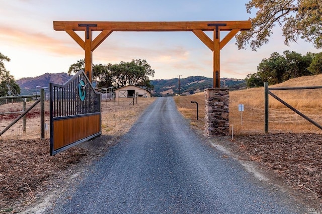 view of street with driveway and a mountain view
