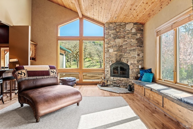 living area with plenty of natural light, high vaulted ceiling, wood finished floors, and wood ceiling