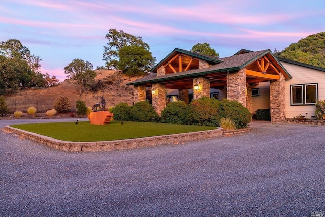 view of home's exterior with stone siding and a lawn