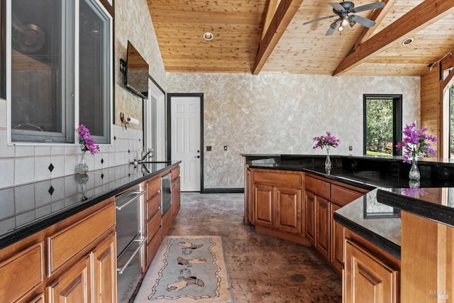 kitchen with lofted ceiling with beams, wallpapered walls, wood ceiling, dark countertops, and brown cabinets