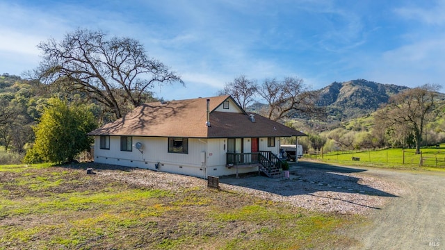 rear view of house with crawl space, fence, and a mountain view