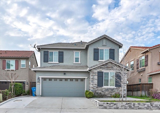 traditional-style home featuring stucco siding, fence, an attached garage, stone siding, and driveway