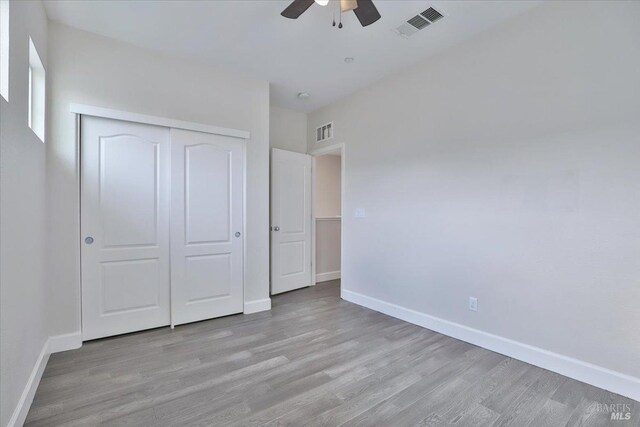 unfurnished bedroom with baseboards, visible vents, a closet, and light wood-type flooring