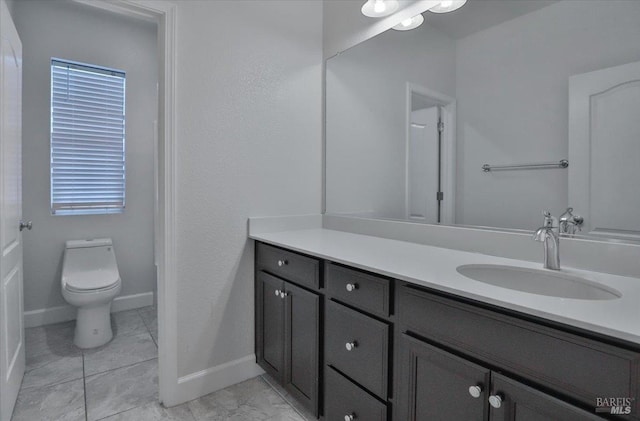 bathroom featuring baseboards, toilet, and vanity