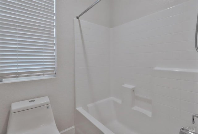 bathroom with tub / shower combination and toilet