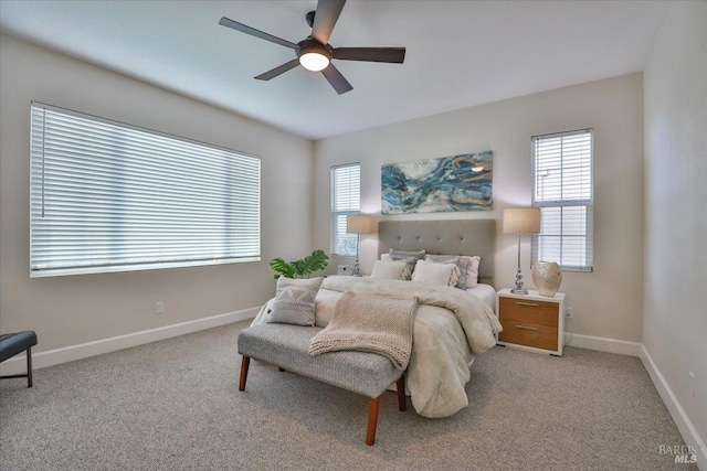 bedroom with light carpet, baseboards, and a ceiling fan