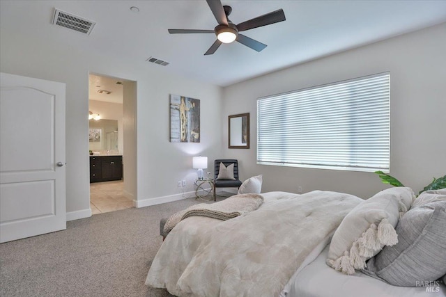 carpeted bedroom featuring ensuite bathroom, baseboards, ceiling fan, and visible vents