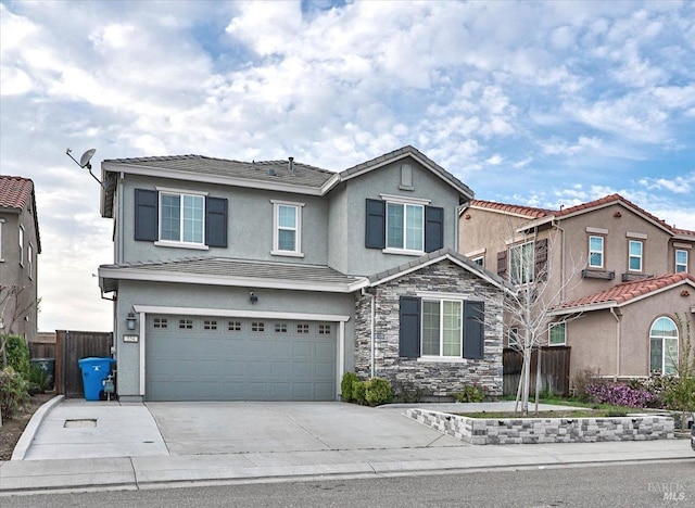 view of front of house with concrete driveway, stucco siding, fence, an attached garage, and stone siding
