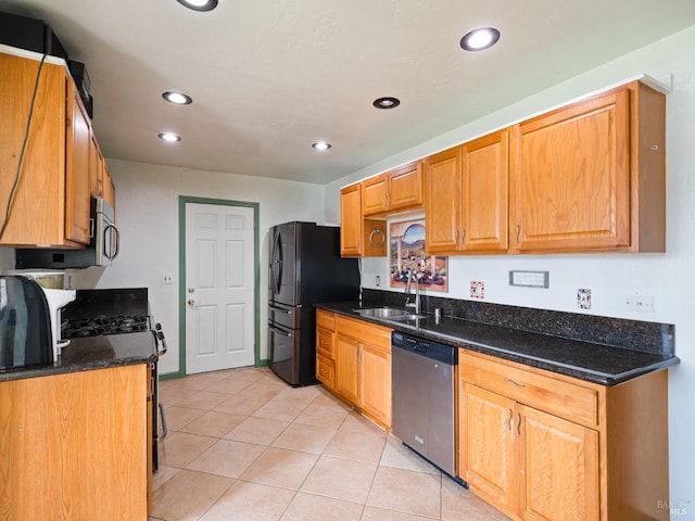 kitchen with recessed lighting, light tile patterned flooring, dark stone counters, stainless steel appliances, and a sink