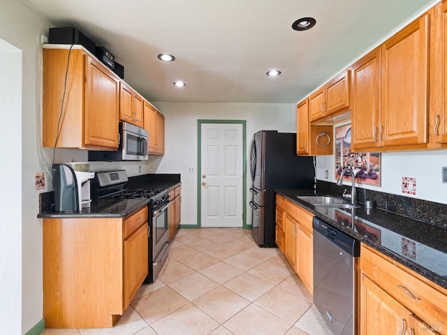 kitchen with stainless steel appliances, recessed lighting, a sink, and dark stone counters