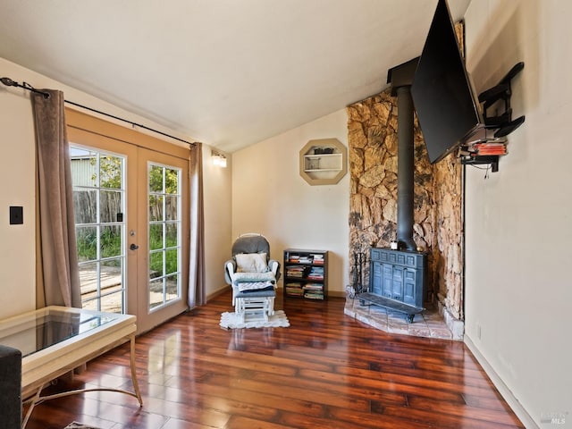 sitting room featuring french doors, wood finished floors, a wood stove, and lofted ceiling