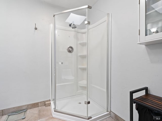 bathroom featuring a stall shower and baseboards