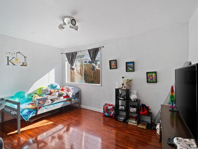 bedroom featuring baseboards and wood finished floors