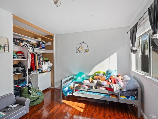bedroom with a closet, baseboards, and wood finished floors