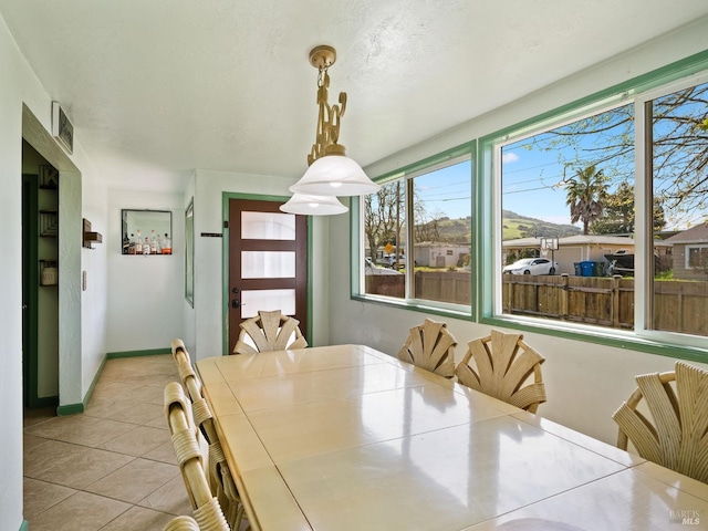 tiled dining area with baseboards and visible vents