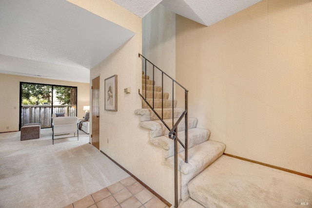 stairs with baseboards, carpet floors, a textured ceiling, and tile patterned floors