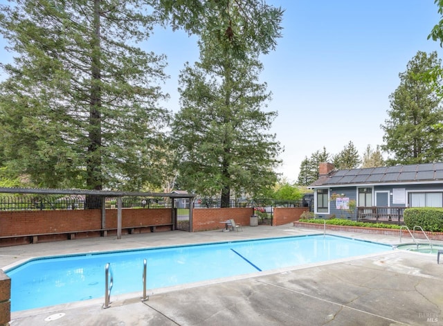 community pool featuring a patio area and fence