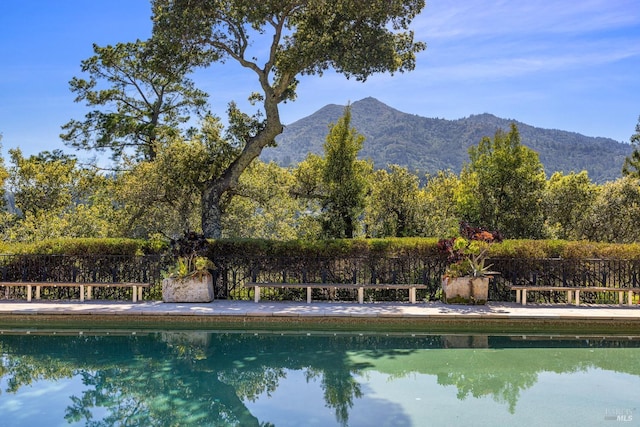 view of swimming pool featuring a fenced in pool and a mountain view