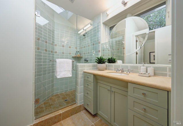 full bathroom featuring tile patterned floors, tile walls, vanity, and a stall shower