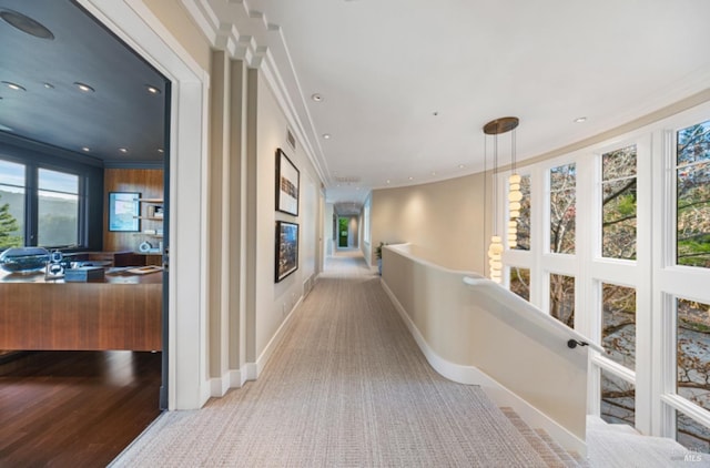 corridor featuring crown molding, carpet, and baseboards