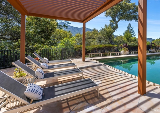 view of pool with a patio area, fence, a fenced in pool, and a mountain view