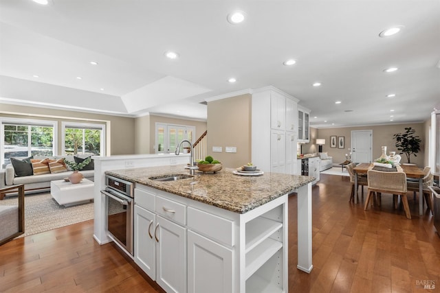 kitchen with open floor plan, dark wood-style flooring, a sink, and oven