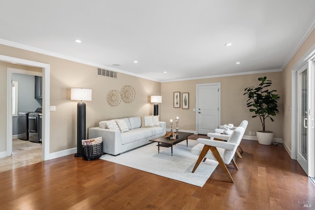 living area with baseboards, ornamental molding, visible vents, and light wood-type flooring