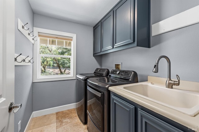 clothes washing area with washer and clothes dryer, cabinet space, a sink, and baseboards