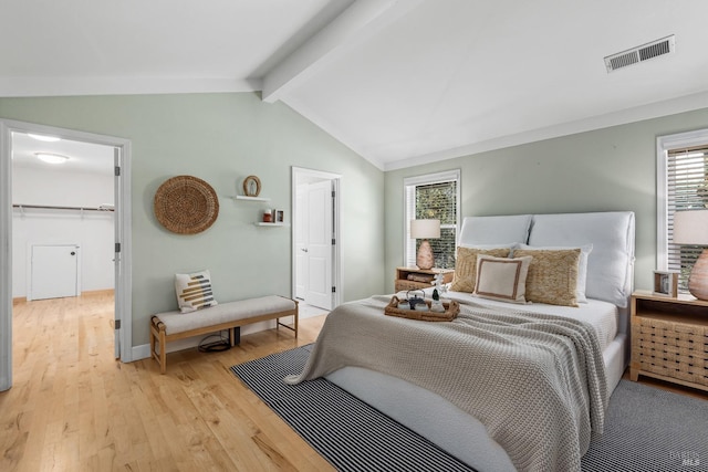 bedroom with lofted ceiling with beams, baseboards, light wood-style flooring, and visible vents