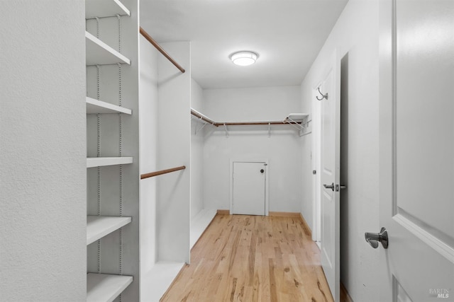walk in closet with wood finished floors