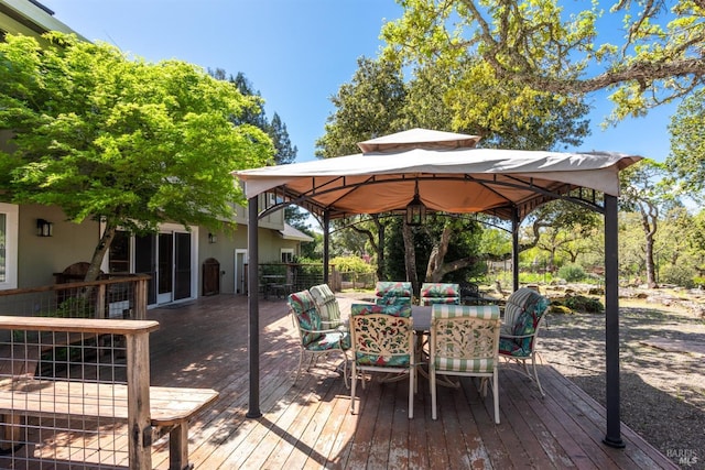deck with outdoor dining area and a gazebo