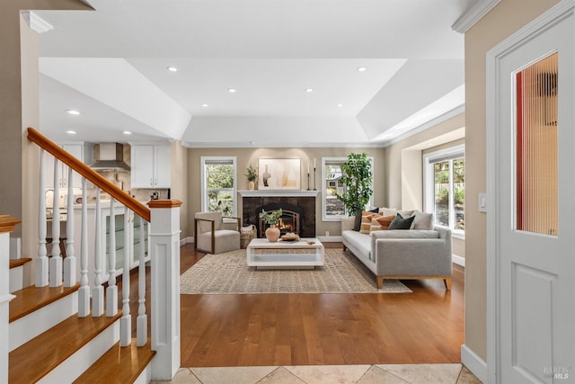 living area with plenty of natural light, a premium fireplace, stairs, and recessed lighting