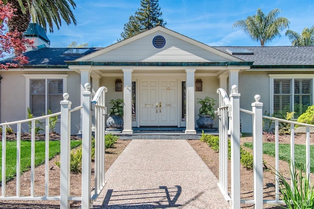 entrance to property with stucco siding and covered porch