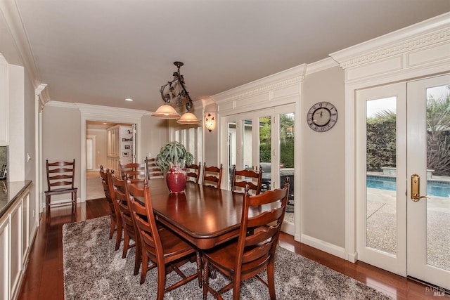 dining space featuring dark wood finished floors, baseboards, crown molding, and french doors