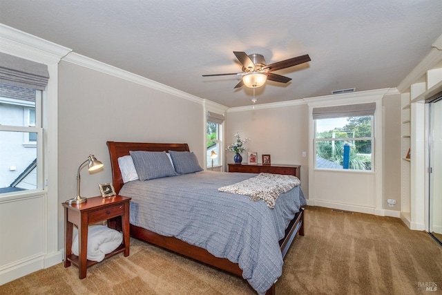 bedroom featuring crown molding, baseboards, visible vents, and carpet