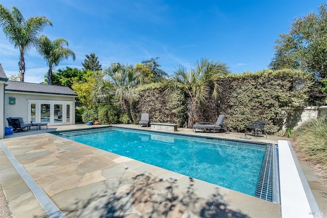 outdoor pool featuring a patio area and french doors