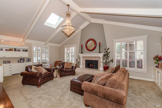 living area with light carpet, beamed ceiling, a tiled fireplace, and a skylight